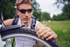 48976678-cyclist-checks-wheel.jpg